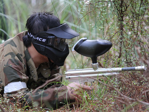 Paintball action in a woodland game zone